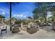 Outdoor lounge area featuring comfortable seating, a fire pit and lush greenery, perfect for relaxation at 28375 N 130Th Dr, Peoria, AZ 85383