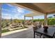 Inviting covered patio featuring a built-in grill, outdoor seating, and a serene rock waterfall feature with lush landscaping at 28375 N 130Th Dr, Peoria, AZ 85383