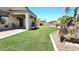 Backyard featuring a well-manicured lawn, stone planter, and partially covered patio at 3002 W Caravaggio Ln, Phoenix, AZ 85086
