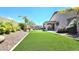 Backyard boasting an artificial turf lawn, mature landscaping, and covered patio at 3002 W Caravaggio Ln, Phoenix, AZ 85086