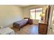 Well-lit bedroom with wood flooring, dresser, and a twin bed at 3002 W Caravaggio Ln, Phoenix, AZ 85086