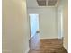 Hallway with hardwood floors leading to a well-lit room featuring a door at 3002 W Caravaggio Ln, Phoenix, AZ 85086