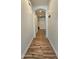 Hallway featuring hardwood floors, white walls, and an arched entrance into a room with natural light at 3002 W Caravaggio Ln, Phoenix, AZ 85086