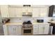 Well-lit kitchen featuring white cabinets, stainless oven, and white backsplash at 3002 W Caravaggio Ln, Phoenix, AZ 85086