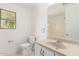 Bright bathroom with a neutral vanity, toilet, and a window bringing in natural light at 304 E Beth Dr, Phoenix, AZ 85042