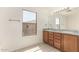 Bathroom with double sink vanity, large mirror, tile floors, and a large window at 304 E Beth Dr, Phoenix, AZ 85042
