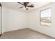 This carpeted bedroom features a ceiling fan and a large window with views at 304 E Beth Dr, Phoenix, AZ 85042
