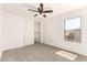 Bright bedroom featuring neutral carpet, a ceiling fan, and ample natural light from a window at 304 E Beth Dr, Phoenix, AZ 85042