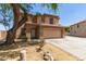Two-story home featuring a two-car garage, a well-manicured front yard, and desert landscaping at 304 E Beth Dr, Phoenix, AZ 85042