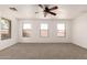 Carpeted living space with neutral walls, lots of windows, and a ceiling fan at 304 E Beth Dr, Phoenix, AZ 85042