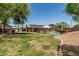 Expansive backyard featuring a sparkling pool, covered patio, lush lawn, and desert landscaping at 3059 E Tyson Ct, Gilbert, AZ 85295