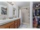 Bathroom with dual sinks, stone countertops, walk-in shower, and access to closet at 3059 E Tyson Ct, Gilbert, AZ 85295