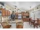 Bright kitchen featuring wood cabinets, a granite island, and tiled floors connecting to the dining room at 3059 E Tyson Ct, Gilbert, AZ 85295