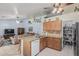 Open-concept kitchen featuring wood cabinets, a central island, and direct view to the living room at 3059 E Tyson Ct, Gilbert, AZ 85295
