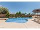 Inviting backyard pool with a rock waterfall feature, desert landscaping, and ample space for lounging at 3059 E Tyson Ct, Gilbert, AZ 85295
