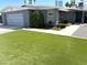 This single-story home boasts an artificial lawn, gray exterior, and a convenient attached garage in a sunny neighborhood at 3137 N 4Th Ave, Phoenix, AZ 85013