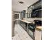 Cozy kitchen with dark green cabinetry, stainless steel appliances, and black and white tile at 3137 N 4Th Ave, Phoenix, AZ 85013