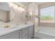 Well-lit bathroom with double sinks, elegant mirrors, and a luxurious bathtub at 3521 N Barron --, Mesa, AZ 85207