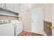 Bright laundry room featuring white washer and dryer units with overhead cabinets for organized storage at 3521 N Barron --, Mesa, AZ 85207