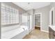 Bathroom featuring a bathtub, glass shower, and access to the walk-in closet at 3565 E Meadowview Dr, Gilbert, AZ 85298