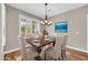 Formal dining area featuring a wooden table and 6 upholstered chairs next to a large window at 3565 E Meadowview Dr, Gilbert, AZ 85298