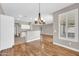 Bright dining room with wood floors, modern chandelier, and a view into the kitchen at 3565 E Meadowview Dr, Gilbert, AZ 85298