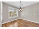 Bright, empty room with wood floors, plantation shutters, and neutral paint at 3565 E Meadowview Dr, Gilbert, AZ 85298