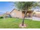 The house backyard features lawn, a covered patio, and a tree at 425 S 93Rd Pl, Mesa, AZ 85208