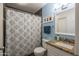 Bathroom featuring granite countertop, framed mirror, shower with patterned curtain, and blue accent wall at 4431 N 21St Pl, Phoenix, AZ 85016