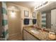 Bathroom with white vanity, granite countertop, framed mirror, and shower with striped curtain at 4431 N 21St Pl, Phoenix, AZ 85016