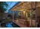Inviting backyard features a covered patio with lights, a tranquil pond, garden beds, and comfortable seating at 4431 N 21St Pl, Phoenix, AZ 85016