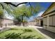 A backyard featuring desert landscaping, artificial turf, and decorative stone pillars for easy maintenance and relaxation at 4512 W Rushmore Dr, Anthem, AZ 85087