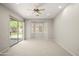 Inviting bedroom with neutral carpet, a ceiling fan, backyard views through windows, and a sliding door at 4512 W Rushmore Dr, Anthem, AZ 85087