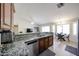 Open kitchen with granite countertops, stainless steel dishwasher, and adjacent dining area at 4558 E Libby St, Phoenix, AZ 85032