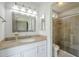 Bathroom with granite-topped vanity, decorative mirror and lighting, plus a tiled shower at 5330 E Tierra Buena Ln, Scottsdale, AZ 85254