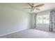 Bright bedroom with neutral carpet, ceiling fan, and a large window with curtains at 5330 E Tierra Buena Ln, Scottsdale, AZ 85254