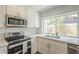Bright kitchen features white cabinets, stainless steel appliances, and a window over the sink at 5330 E Tierra Buena Ln, Scottsdale, AZ 85254