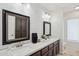 Bathroom with double sinks, framed mirrors, white countertops, wood cabinets, and modern fixtures at 5415 E Juniper Ave, Scottsdale, AZ 85254