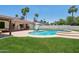 Beautiful backyard featuring a refreshing pool, green lawn, and covered patio perfect for entertaining at 5415 E Juniper Ave, Scottsdale, AZ 85254