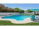 Sparkling pool with spa, blue patio furniture and shade umbrella create a backyard oasis at 5415 E Juniper Ave, Scottsdale, AZ 85254