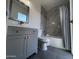 Modern bathroom features a gray vanity, toilet, and shower-tub with marble style tile at 5539 W Wilshire Dr, Phoenix, AZ 85035
