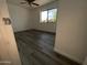 Bright bedroom features a ceiling fan, wood-look flooring, and a sunlit window at 5539 W Wilshire Dr, Phoenix, AZ 85035