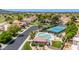 Aerial view showcases a community pool, tennis court, lush landscaping, and well-maintained homes in a desert setting at 6597 N 79Th Pl, Scottsdale, AZ 85250