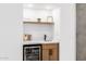 Wet bar featuring a wine refrigerator, wooden cabinets, and a small sink at 6597 N 79Th Pl, Scottsdale, AZ 85250
