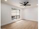 Minimalist bedroom showcasing hardwood floors, large windows, and modern ceiling fan at 6597 N 79Th Pl, Scottsdale, AZ 85250