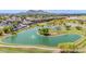 Scenic aerial view of a golf course featuring a serene pond with a fountain and desert landscaping, with mountains in the background at 6597 N 79Th Pl, Scottsdale, AZ 85250