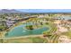 Picturesque aerial view of a golf course and community showcasing a water feature and lush greenery, set against mountain views at 6597 N 79Th Pl, Scottsdale, AZ 85250