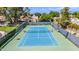 Outdoor tennis court featuring a well-maintained green and blue surface, surrounded by fencing and mature landscaping at 6597 N 79Th Pl, Scottsdale, AZ 85250