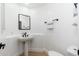 A minimalist powder room with white walls, a pedestal sink, and modern fixtures at 6996 E Mighty Saguaro Way, Scottsdale, AZ 85266