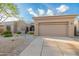 Beige home featuring desert landscaping and a two car garage at 6996 E Mighty Saguaro Way, Scottsdale, AZ 85266